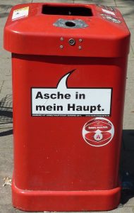 Roter Abfalleimer - Standort: Hamburg. Beschriftung: "Asche auf mein Haupt."